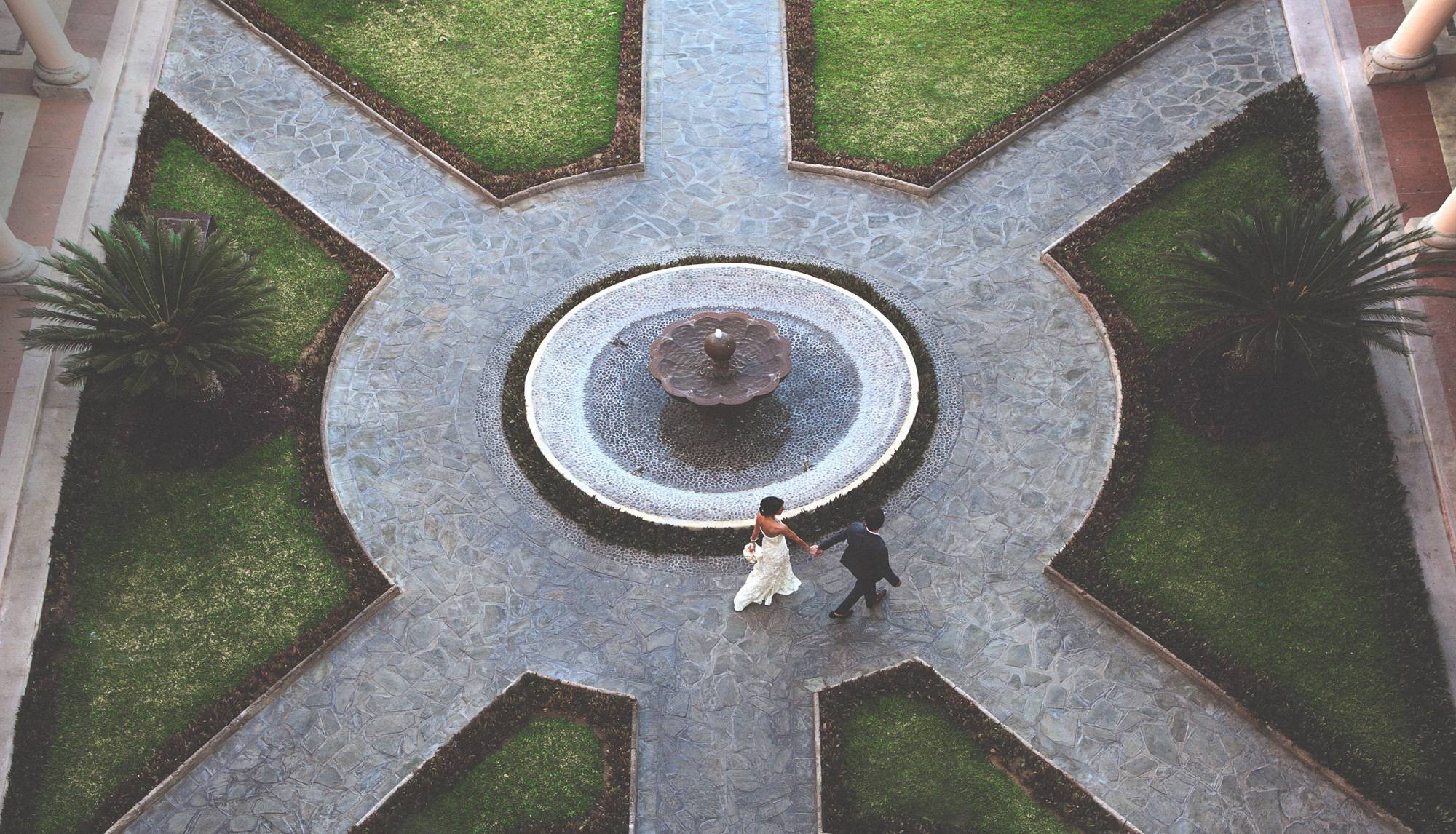 Couple crossing a formal courtyard from above