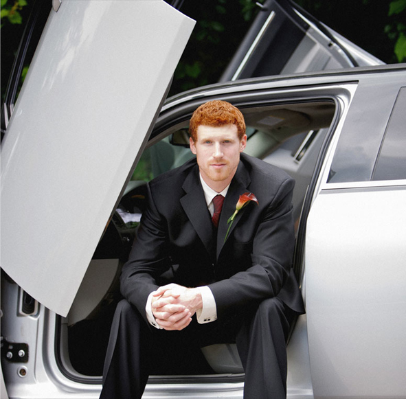 Groom seated in a car doorway