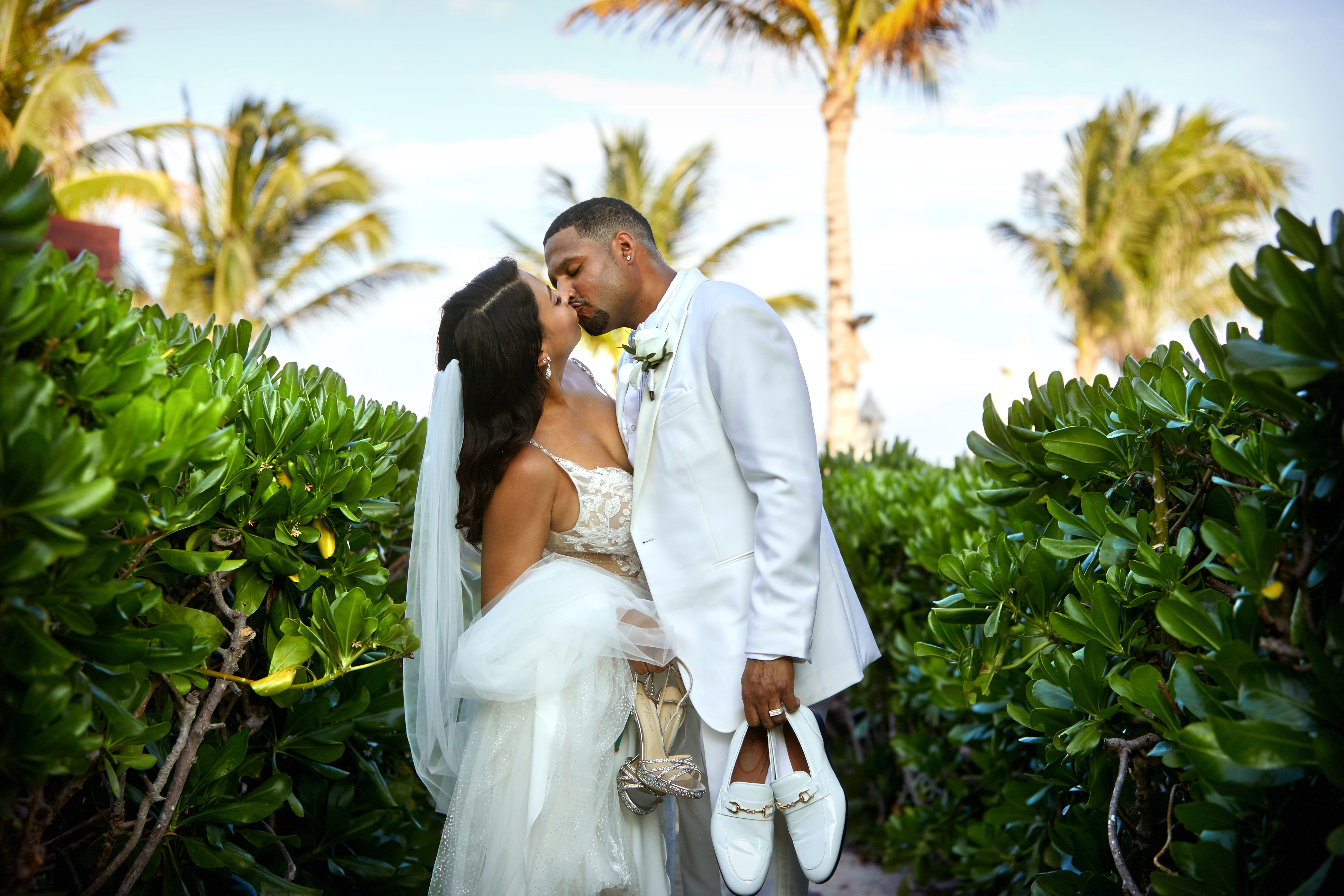 Couple kissing among tropical greenery
